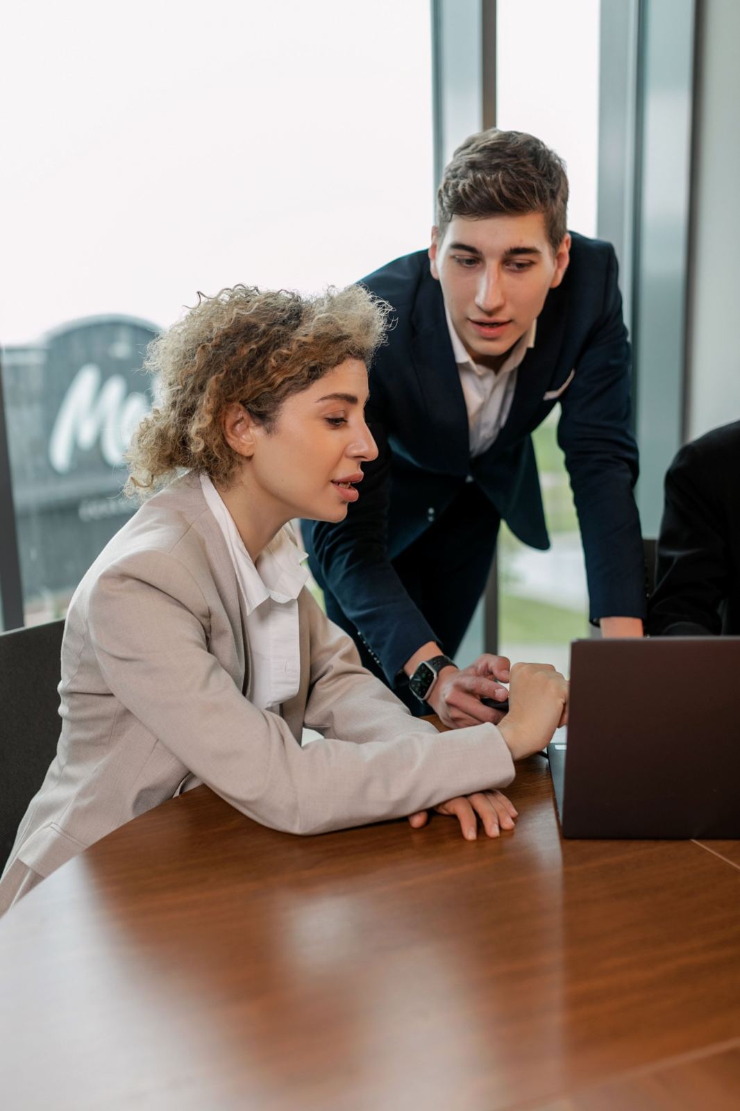 Two colleagues reviewing figures on a laptop