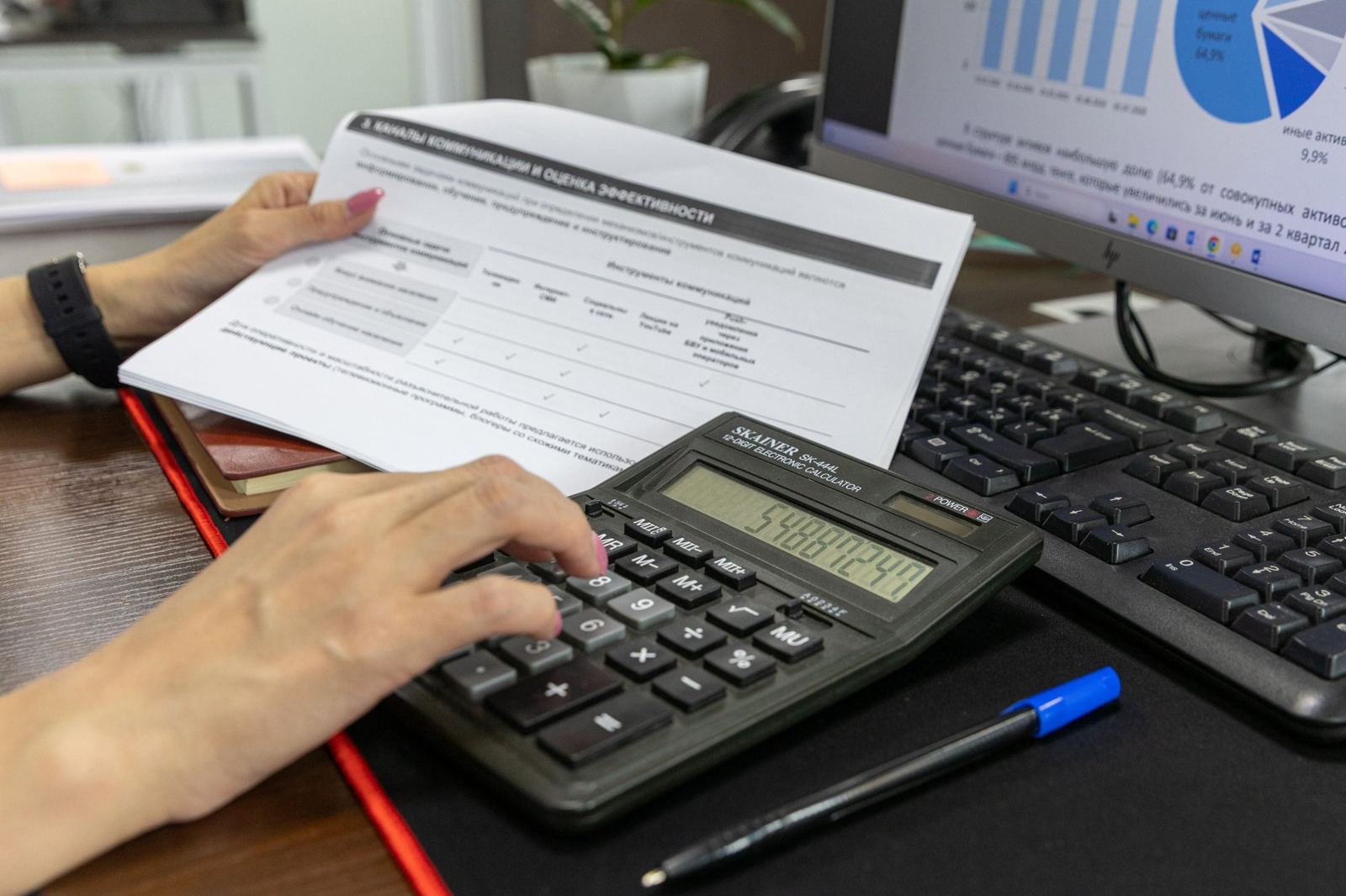 Calculator and financial report beside a computer