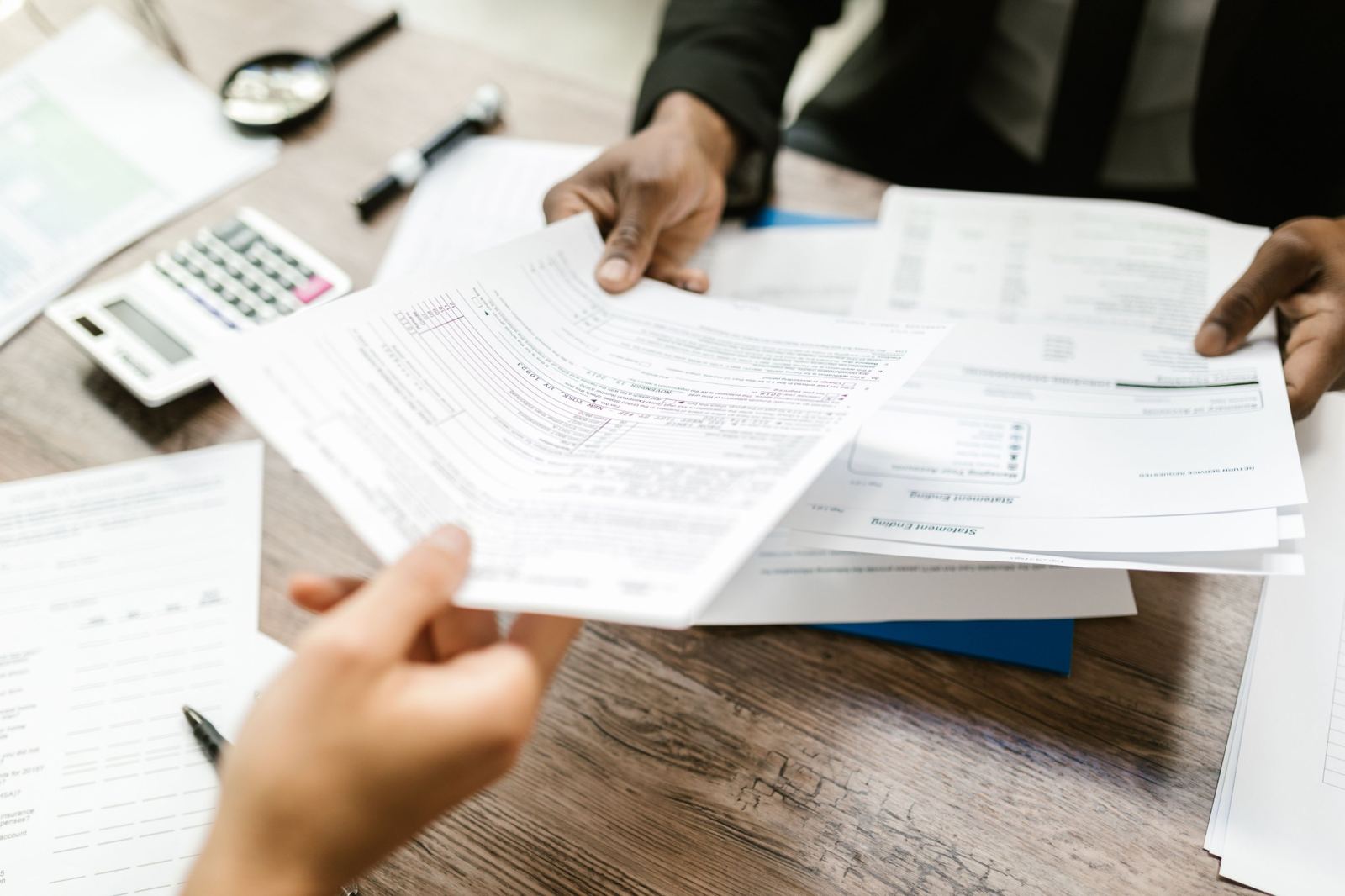Statements and payroll paperwork handed across a desk